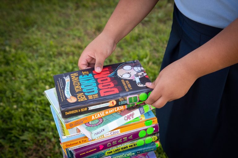 Student with culturally-relevant books from our lending library.