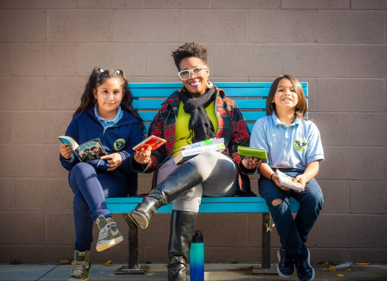 Volunteer working with kids to improve reading skills.